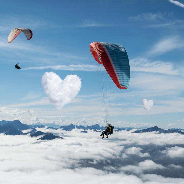 Zwei Tandem Paragleiter über den Wolken auf Wolke 7. Heiratsantrag